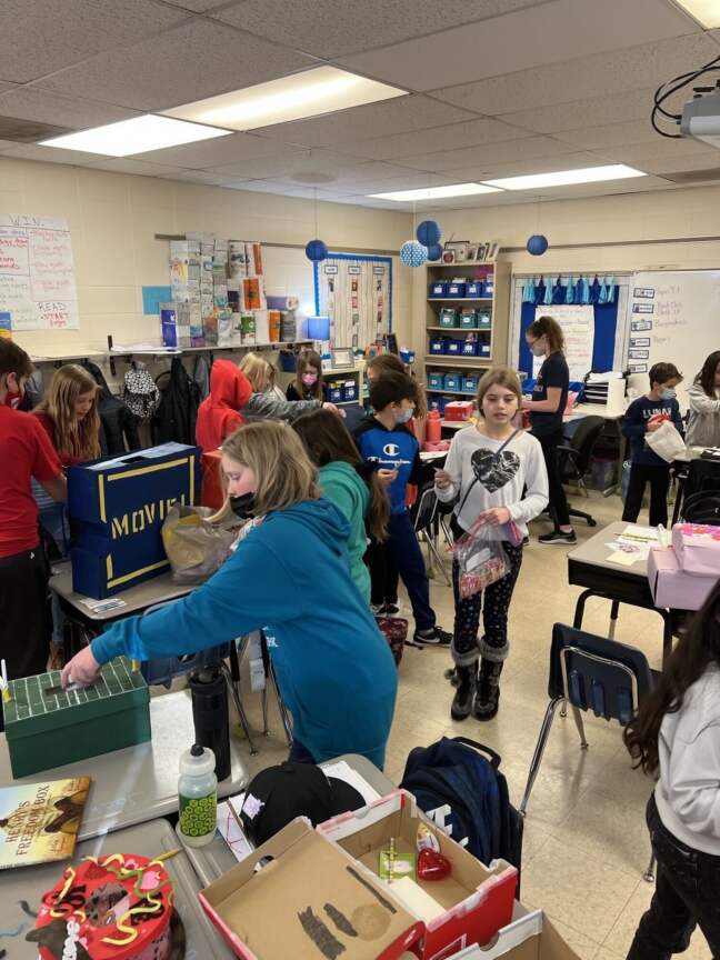 Children in a classroom receiving donated supplies during RAK Week