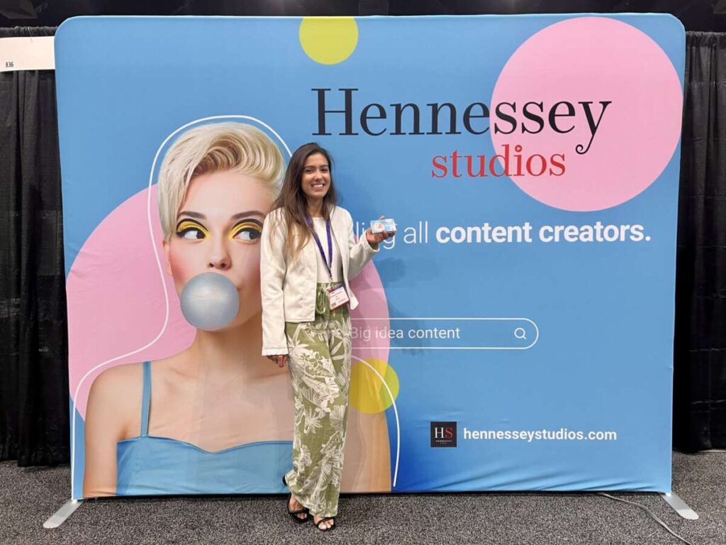Hennessey Studios team member at the company backdrop at the B2B Marketing Expo
