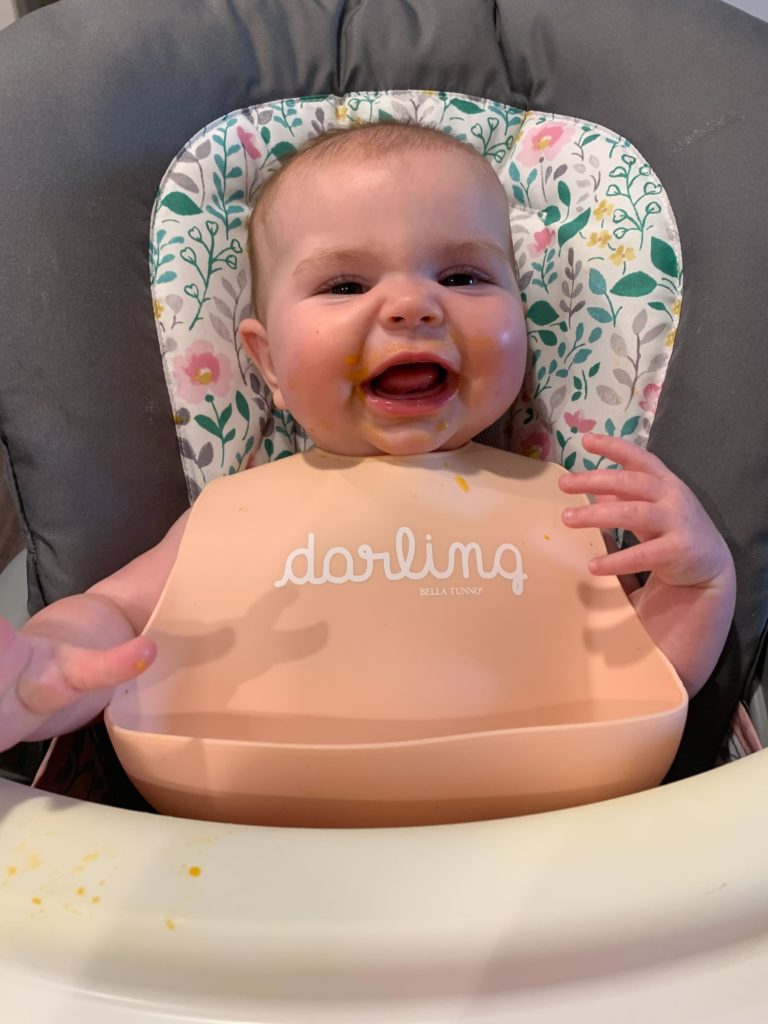 smiling baby sitting in high chair