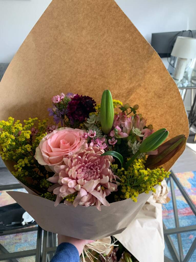Bouquet of pink flowers wrapped in kraft paper from a local florist